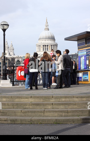 London groupe de touristes sur la rive sud en face de la Cathédrale St Paul en Angleterre Banque D'Images