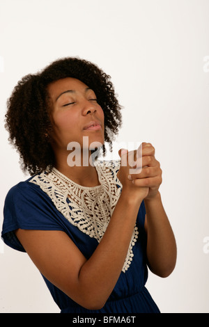 Jeune femme afro antillais qui serre ses mains comme si elle était de prier ou de chanter une chanson de l'evangile Banque D'Images