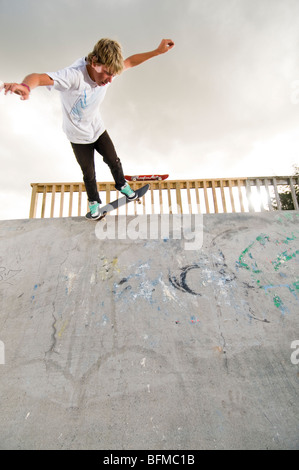 3 garçons faisant des tours dans le skate park avec soleil couchant, Nouvelle-Zélande, Banque D'Images