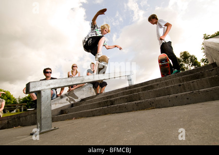 3 garçons faisant des tours dans le skate park avec soleil couchant, Nouvelle-Zélande, Banque D'Images