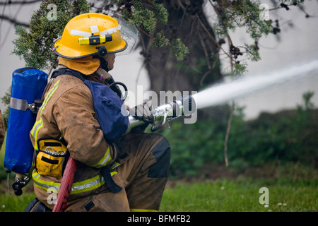 Fire fighter combattre le feu avec le tuyau, le Mardi, Novembre 17, 2009. Banque D'Images