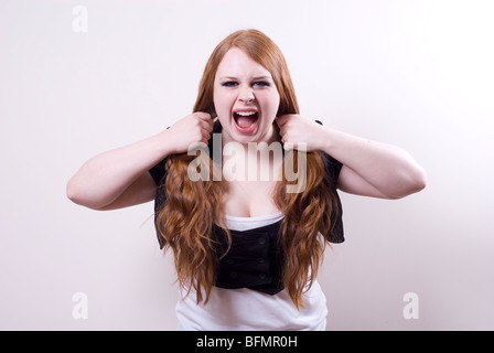 Jeune femme en colère tirant les cheveux et crier Banque D'Images