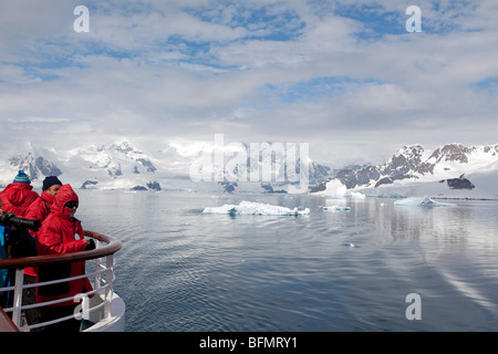 L'Antarctique, l'Antarctique Penisula, Paradise Harbour, touristes vêtus de l'uniforme de l'Antarctique montre que le navire quitte le port de paradis. Banque D'Images