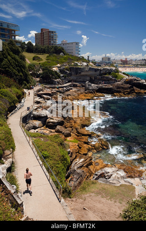L'Australie, New South Wales, Sydney. Jogger sur le chemin côtier à Bondi Coofee. Banque D'Images