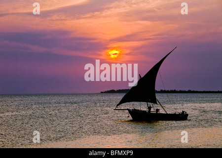 La Tanzanie, Zanzibar. Un dhow voiles retour à port de Zanzibar au coucher du soleil. Banque D'Images