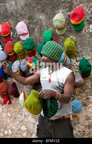 La Tanzanie, Zanzibar, Stone Town. L'esprit d'un chapelier avec un affichage sur le mur de l'ancien fort omanais. Banque D'Images