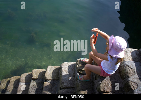 France, Bretagne. Une jeune fille la capture de crabes dans le port de La Trinite Sur Mer. (MR) Banque D'Images