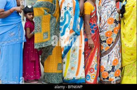 Staring indian Girl standing in entre femmes portant le sari coloré dans une file d'attente à Puttaparthi, Andhra Pradesh, Inde Banque D'Images