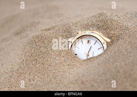 Enterré dans le sable watch prises pour illustrer le concept des sables du temps Banque D'Images