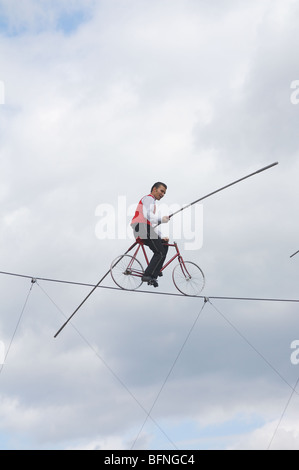 Membre de The Flying Wallendas bicyclettes à travers un fil Banque D'Images