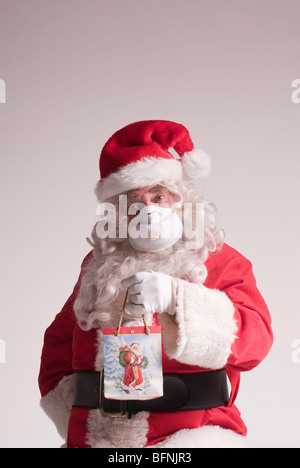 65 ans, homme habillé en père Noël pour Noël portant un masque respiratoire de protection contre le virus H1N1 (grippe porcine) Banque D'Images