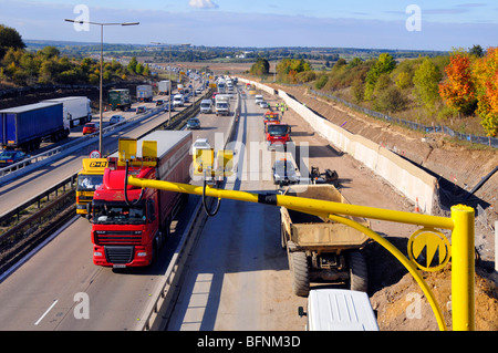 Route d'autoroute M25 élargissant l'épaulement dur et le trafic du chantier de construction de mur de soutènement en béton pris sur le portique de caméra à vitesse variable Essex Angleterre Royaume-Uni Banque D'Images