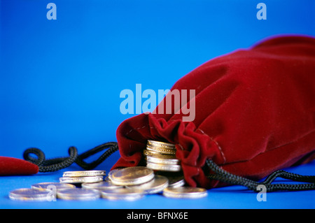 61776 : Concept de la NVM ; pièces et sac sur fond bleu Banque D'Images