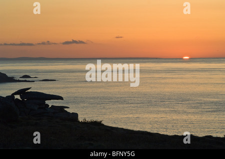 Dawn soleil montant de la mer au large des îles Scilly sur St Marys, avec Pulpit Rock vers la gauche.