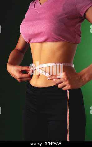 Adolescent indien mesurant la taille avec un ruban de mesure ; MR#442 Banque D'Images
