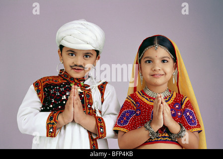 Garçon et fille habillés comme couple Gujarati mains pliées namaste bienvenue pose inde robe de fantaisie indienne MR#498 & 497 Banque D'Images