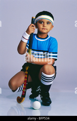 Enfant indien en costume de fantaisie de joueur de hockey avec bâton de hockey ; Inde ; Asie ; MR#498 Banque D'Images