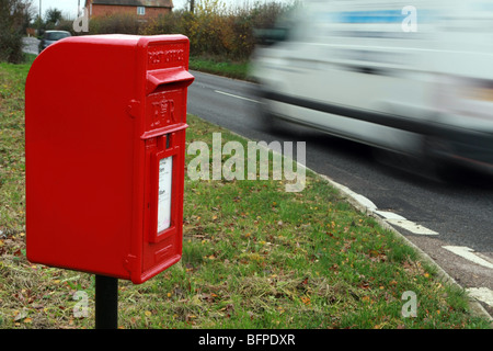 Le trafic passant floue une boîte de poste rural situé sur l'A28 entre Tenterden et Rolvenden, Kent Banque D'Images