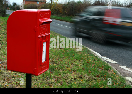 Le trafic passant floue une boîte de poste rural situé sur l'A28 entre Tenterden et Rolvenden, Kent Banque D'Images