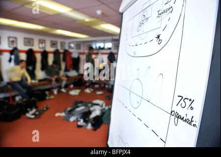 Un tableau blanc avec des footballeurs tactique croquis dans un vestiaire avec kit sales empilés sur le plancher UK Banque D'Images