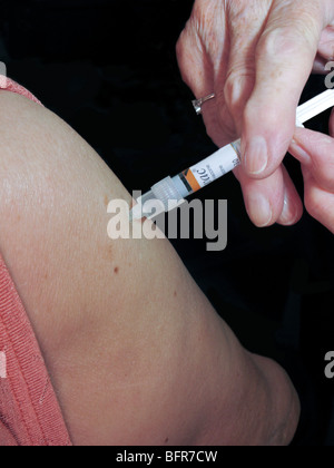 Femme ayant la grippe jab (une précaution contre le virus de l'hiver) Banque D'Images