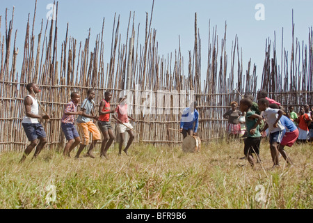 Les garçons avec des bâtons de danse zoulou traditionnel au kraal Banque D'Images