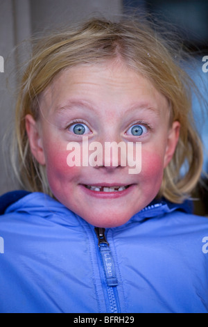 Un pâle, rosy cheeked fillette de six ans a faire des grimaces. Banque D'Images