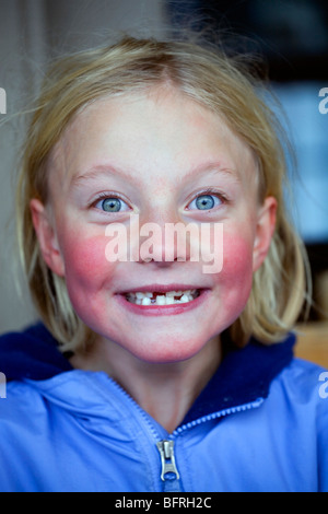 Un pâle, rosy cheeked fillette de six ans a faire des grimaces. Banque D'Images