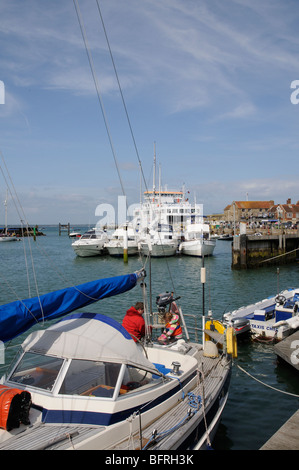 Les bateaux dans le port de Yarmouth Île de Wight dans le sud de l'Angleterre l'homme et enfant de poupe d'un yacht en visite Banque D'Images