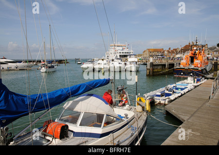 Les bateaux dans le port de Yarmouth Île de Wight dans le sud de l'Angleterre l'homme et enfant de poupe d'un yacht en visite Banque D'Images