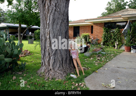 Grande poupée Barbie avec T-shirt 'Daddy's girl' s'appuyant sur un arbre dans le jardin de quelqu'un, Dallas, Texas Banque D'Images