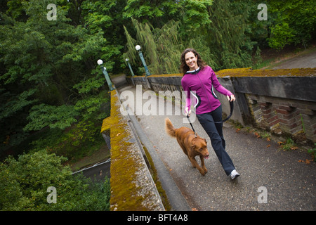 Woman Walking Dog dans l'Arboretum, Seattle, Washington, USA Banque D'Images