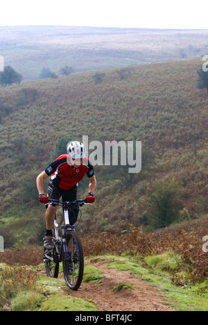 Un vélo de montagne grimpe une colline escarpée dans le collines de Quantock. Somerset, Royaume-Uni. Banque D'Images