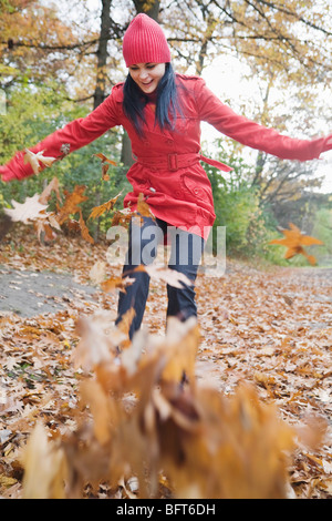 Femme dans les feuilles d'automne Banque D'Images