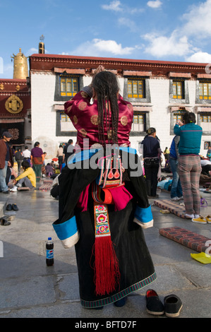 Un tibétain woman praying at Temple du Jokhang à Lhassa au Tibet carrés Barkor Banque D'Images