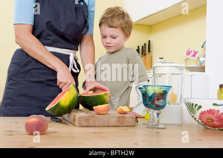 Garçon et mère de fruits préparation Banque D'Images