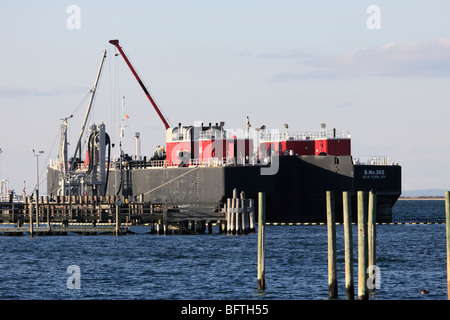 Un réservoir d'huile double coque barge décharger sa cargaison d'huile à de centrale, Port Jefferson, Long Island, NY Banque D'Images