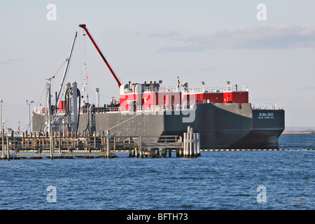 Un réservoir d'huile double coque barge décharger sa cargaison d'huile à de centrale, Port Jefferson, Long Island, NY Banque D'Images