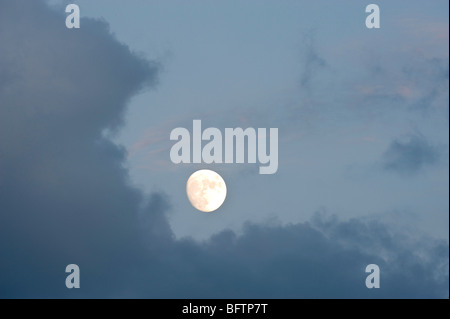 La hausse pleine lune peeking de derrière les nuages en soirée, le Grand Sudbury, Ontario, Canada Banque D'Images