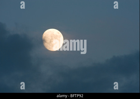 La hausse pleine lune peeking de derrière les nuages en soirée, le Grand Sudbury, Ontario, Canada Banque D'Images