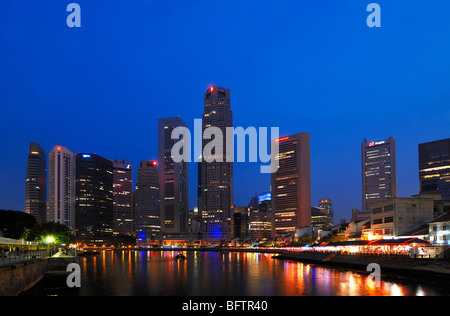 Paysage urbain, paysage urbain ou Skyline de gratte-ciel sur Boat Quay, ou le quartier financier le long de la rivière Singapour, éclairé la nuit, Singapour Banque D'Images