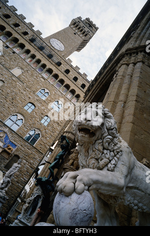 Florence. L'Italie. Flaminio Vacca's 16ème siècle Medici Lion dans la Loggia dei Lanzi, et le Palazzo Vecchio sur la Piazza della Signoria. Banque D'Images