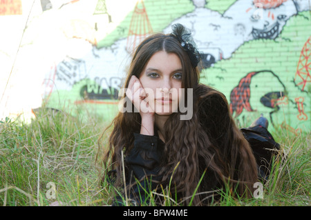 Young woman posing in front of wall graffiti Banque D'Images