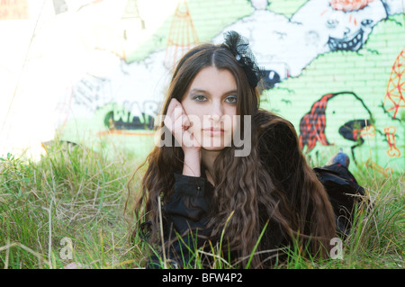 Young woman posing in front of wall graffiti Banque D'Images