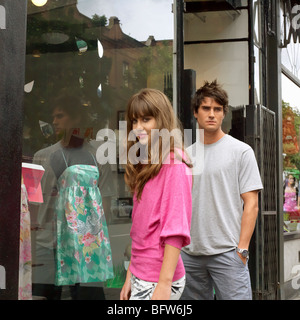 Jeune femme et l'homme à l'extérieur d'une boutique Banque D'Images