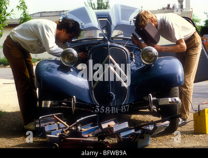 Deux passionnés travaillant sur un 1950 Citroen Traction Avant. Banque D'Images