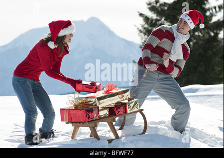 Couple avec traîneau et présente dans la scène d'hiver Banque D'Images