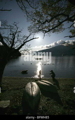 Salon du Loch Lomond, Ecosse. La silhouette d'une mère, la fille et le chien la pagaie dans l'eau à Rowardennan shores. Banque D'Images