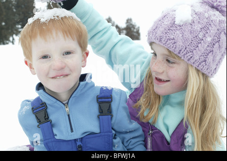 Dumping fille snow ball sur la tête des garçons Banque D'Images