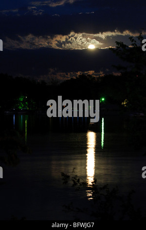 Pleine lune à la hausse dans les nuages et lumières Place Point créer des réflexions sur la rivière des Outaouais, à Toledo, Ohio Banque D'Images